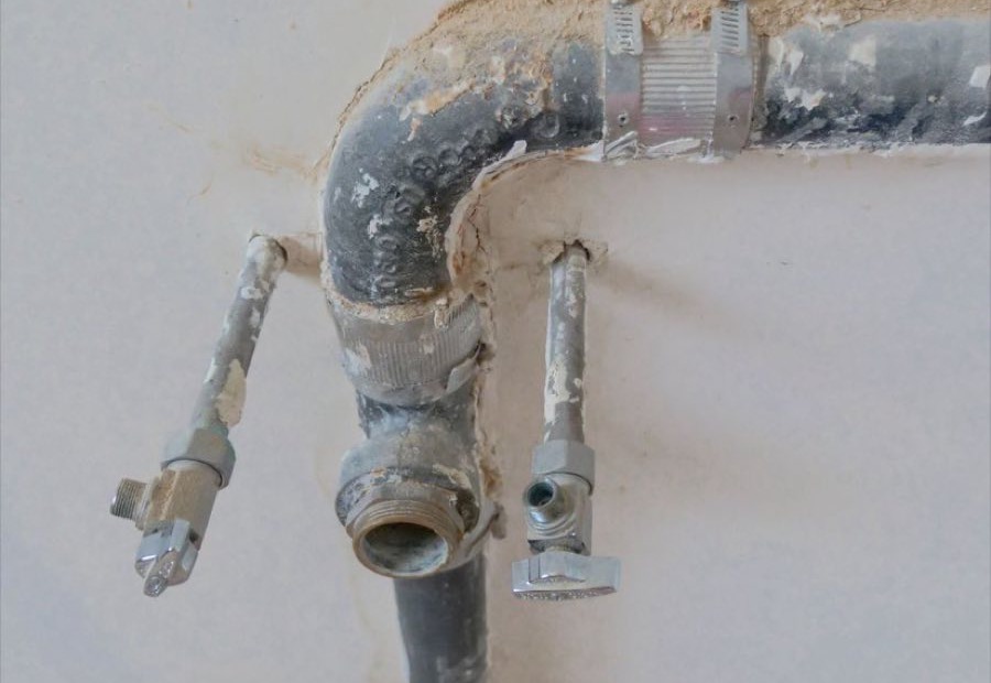 Plumber repairing a supply line under a sink